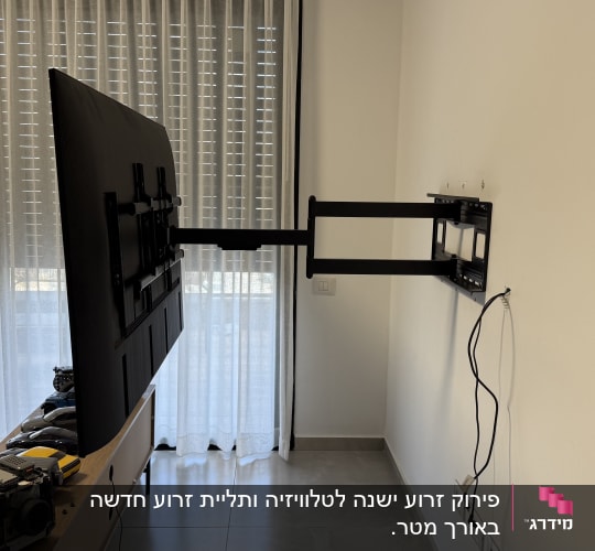 טלוויזיה מותקנת על זרוע קיר בחדר עם וילונות.